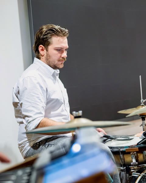 Behind the drum kit, mid-song.
